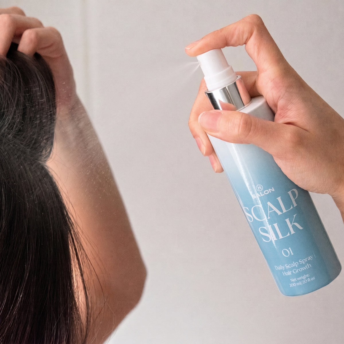 Fine mist application of H Salon Scalp Silk leave-in scalp spray