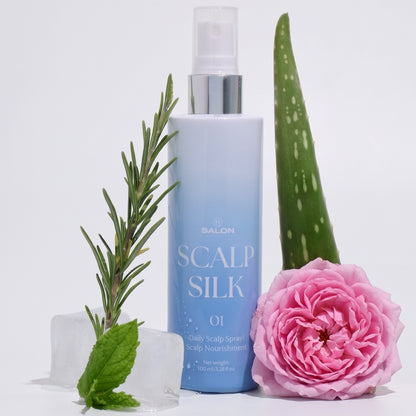 A bottle of H Salon Scalp Silk with a pink rose, rosemary sprig, aloe vera leaf, mint and ice cube on a white background.
